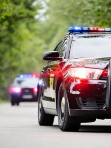 police-patrol-cars-with-flashing-lights-on-forest-road-enforcement-scene-photo